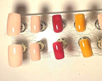 Peut inclure: Dix faux ongles carrés de différentes couleurs, dont le nude, le rouge et le jaune.