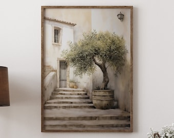 May include: A wooden dresser with six drawers and black handles. The dresser is in front of a white wall with a framed watercolor painting of a stone building with a tree in front of it. A brown lamp with a tripod stand is on the left side of the dresser. A small potted plant is on the right side of the dresser.