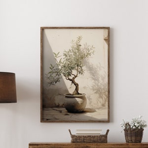 Puede incluir: Una cómoda de madera con seis cajones y tiradores negros. Un estampado enmarcado de un olivo en maceta cuelga sobre la cómoda. Una planta en maceta se encuentra en el suelo frente a la cómoda. Una alfombra marrón está en el suelo frente a la cómoda.