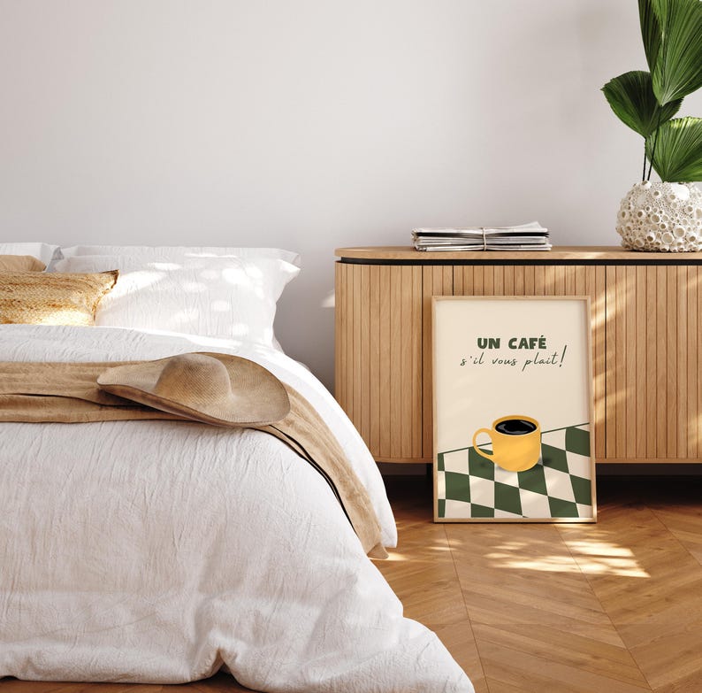 May include: A framed print featuring a yellow coffee cup and the text "UN CAF&Eacute; s'il vous pla&icirc;t!" against a green and white chequered background.