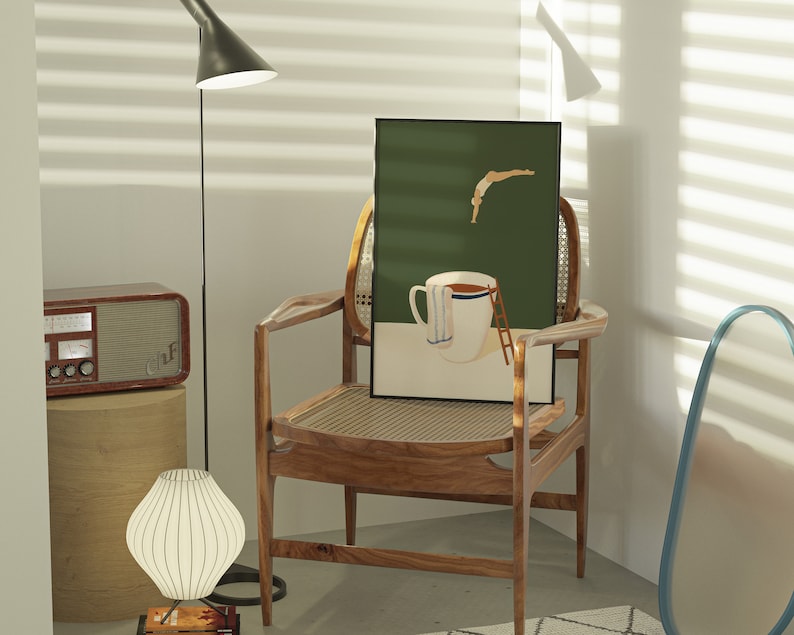 May include: A wooden chair with a woven cane seat and back, a green framed print of a person diving into a cup of coffee, and a white lamp with a white shade.