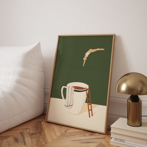 May include: A framed illustration of a person diving into a large white mug with a brown liquid inside. The mug has a blue and white striped towel draped over the side. The background is a dark green color.
