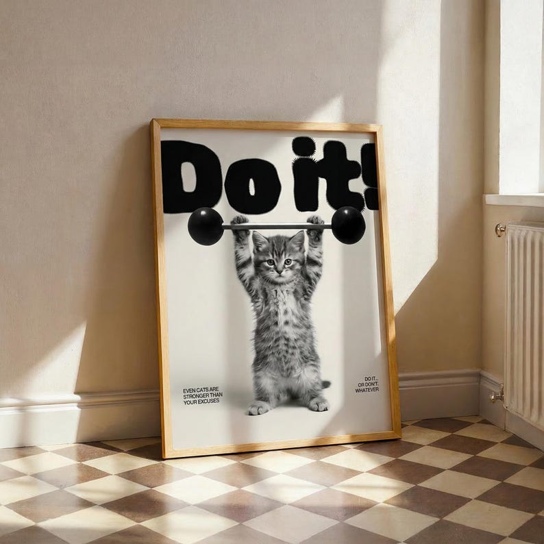 May include: A framed poster features a black and white image of a kitten lifting a barbell. The word "Do it!" is printed above the kitten. The text "Even cats are stronger than your excuses" is printed below the kitten.