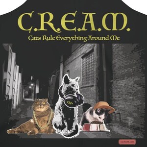 May include: Black apron with the text "C.R.E.A.M. Cats Rule Everything Around Me" in yellow. The apron features a graphic of three cats in an alleyway.
