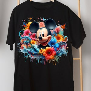 May include: Black t-shirt with a colorful graphic of Mickey Mouse surrounded by flowers and water splatter.