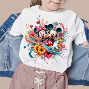 May include: White t-shirt with a colorful graphic of Mickey Mouse and Minnie Mouse with flowers and paint splatters.