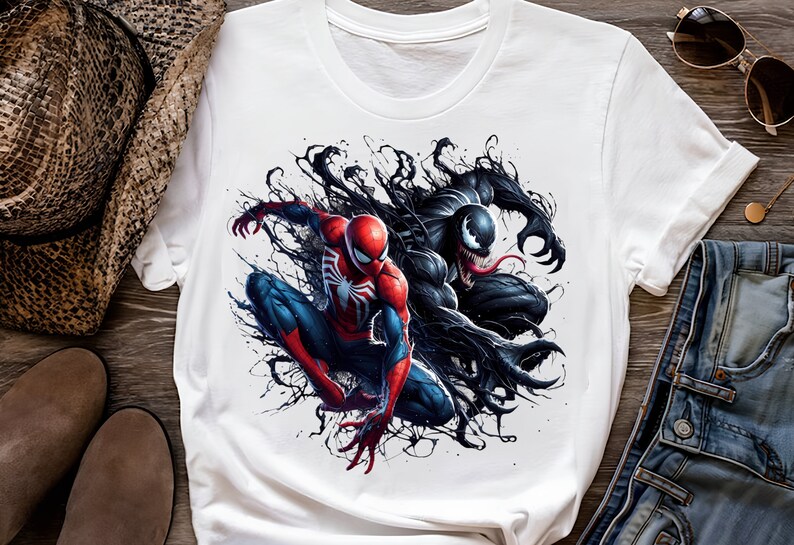 May include: White t-shirt with a graphic print of Spider-Man and Venom in a black and red color scheme. The characters are depicted in a dynamic pose, with Spider-Man swinging and Venom lunging forward.