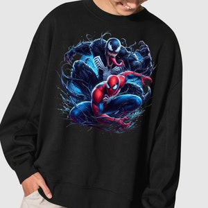 May include: Black sweatshirt with a graphic print of Spider-Man and Venom in a dynamic pose. The image features a blue and black background with splashes of color.