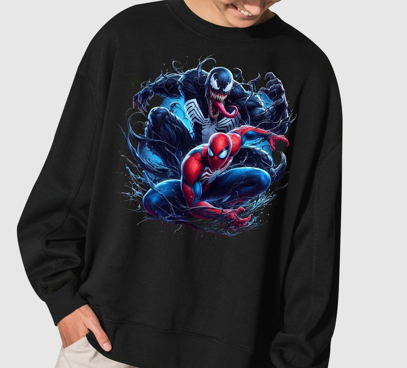 May include: Black sweatshirt with a graphic print of Spider-Man and Venom in a dynamic pose. The image features a blue and black background with splashes of color.