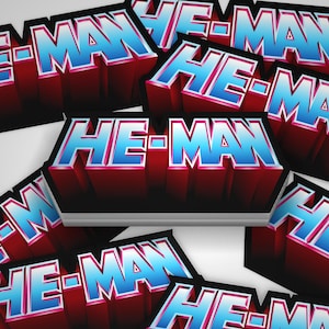 Könnte beinhalten: Mehrere Aufkleber mit dem Text "HE-MAN" im 3D-Stil. Der Text ist blau und rot mit einem weißen Umriss.