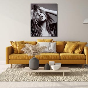 May include: A black and white photographic wall art print featuring a portrait of a person with long, tousled hair, hands raised to their head, and an open-mouthed expression. The high-contrast image captures detailed facial features and hair texture.