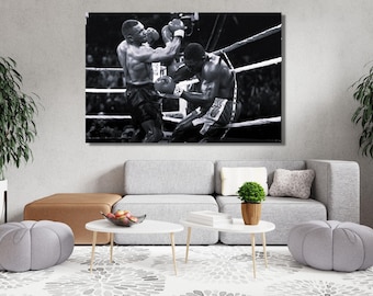 May include: A black and white wall art print depicting a professional boxing match in a ring. The image captures two boxers in motion, with one athlete throwing a punch while the other leans back against the ropes, wearing boxing gloves.