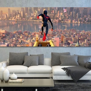 May include: A rectangular wall art print featuring a black and red costumed figure leaping over a dense cityscape with a river and bridge in the background. The scene is set during a golden sunset, casting warm light over the urban buildings.
