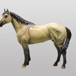 May include: A beige ceramic horse figurine with a black mane and tail. The horse is standing on all four legs with its head held high.