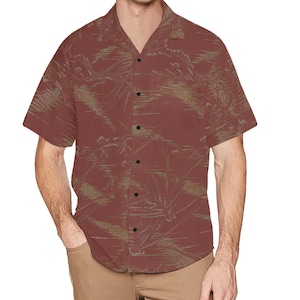 Puede incluir: Camisa de manga corta en un tono marrón rojizo, con un patrón sutil y repetitivo en un tono más claro y apagado. La camisa tiene un cuello clásico y está abotonada, lo que sugiere un estilo casual.