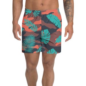以下が含まれることがあります： トロピカルリーフ柄のショートパンツ。色はティール、オレンジ、ブラウン。ウエストはゴムで、迷彩柄のデザイン。軽量素材で作られた膝丈のショートパンツ。
