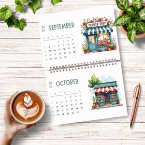K&ouml;nnte beinhalten: Ein Kalender mit Illustrationen eines Blumenladens und einer Buchhandlung. Der Kalender ist auf September und Oktober ge&ouml;ffnet. Die Illustration des Blumenladens zeigt ein blaues Geb&auml;ude mit einer roten Markise und einem Schild mit der Aufschrift "FLOWER SHOP". Die Illustration der Buchhandlung zeigt ein blaues Geb&auml;ude mit einer roten Markise und einem Schild mit der Aufschrift "BOOKSTORE".