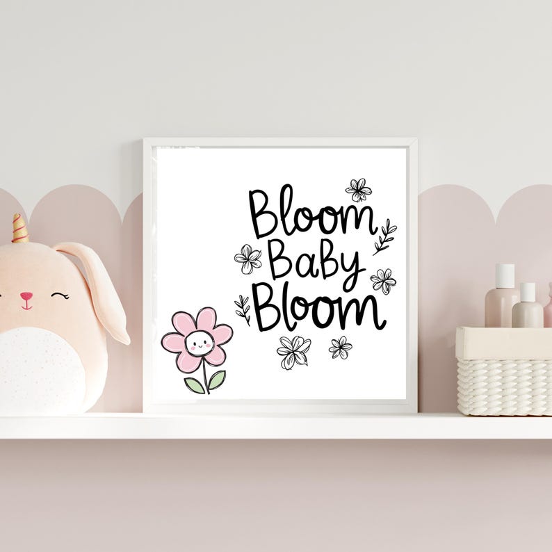 Puede incluir: Una impresi&oacute;n enmarcada en blanco con texto negro que dice "Bloom Baby Bloom" rodeada de peque&ntilde;as flores negras. Una flor rosa con una carita sonriente est&aacute; en la esquina inferior izquierda.