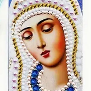 May include: A blue and white diamond painting bookmark depicting the Virgin Mary with a crown of pearls. The bookmark has a light blue tassel.