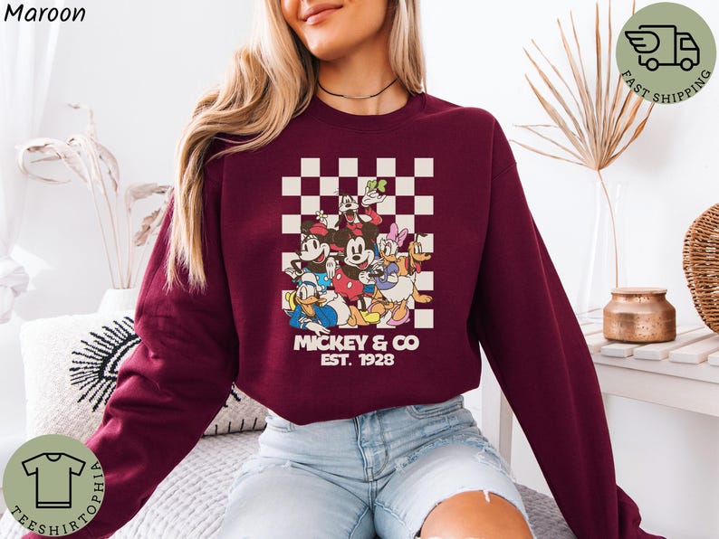 May include: A white ceramic mug with a black handle and the text "But First, Coffee" in a bold, black font. The mug is set against a blurred background, suggesting a cozy setting.