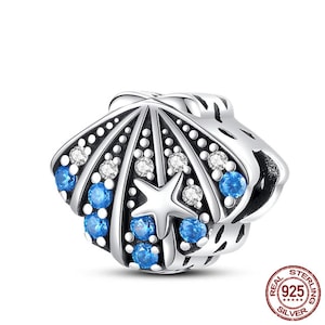 May include: Sterling silver charm featuring a detailed seashell design with blue and white crystals. The charm has a starfish in the center and is perfect for adding a touch of ocean-inspired style to your jewelry.