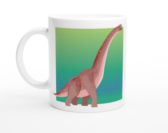 Op de afbeelding: Witte keramische mok met een cartoonillustratie van een bruine dinosaurus met een lange nek op een groene en blauwe gradiëntachtergrond.