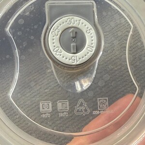 May include: Clear plastic lid with a gray dial featuring numbers from 1 to 30. The dial has an arrow indicating direction. Symbols for -20&deg;C and 120&deg;C are visible, along with a PP recycling symbol.