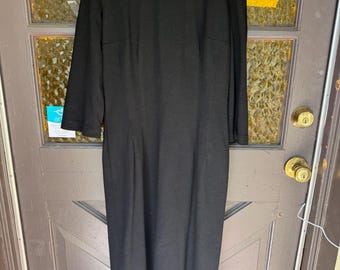 May include: A long black dress with a round neckline and three-quarter sleeves.