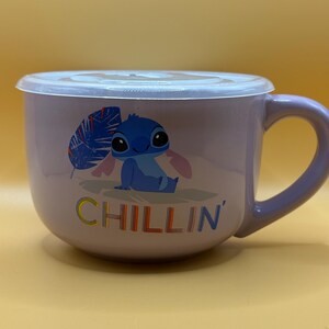 May include: A lavender ceramic bowl with a matching handle and a clear plastic lid. The bowl features a cartoon image of Stitch from Lilo & Stitch, with the word "CHILLIN'" in colorful letters.