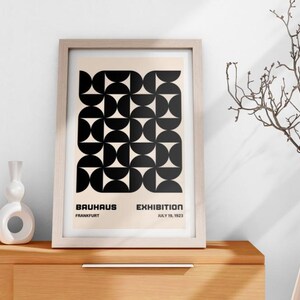May include: A framed black and white geometric print with the text "Bauhaus Exhibition Frankfurt July 16, 1923".