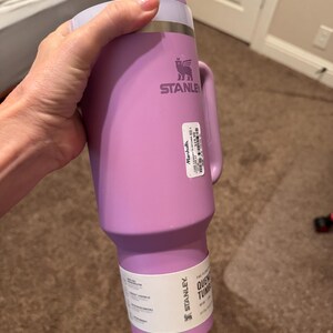 May include: A light purple Stanley Quencher tumbler with a matching handle, a lid, and a white straw. The cup features a metallic rim, a brand logo, and two white product labels attached to the side, one of which includes the text Marshalls.