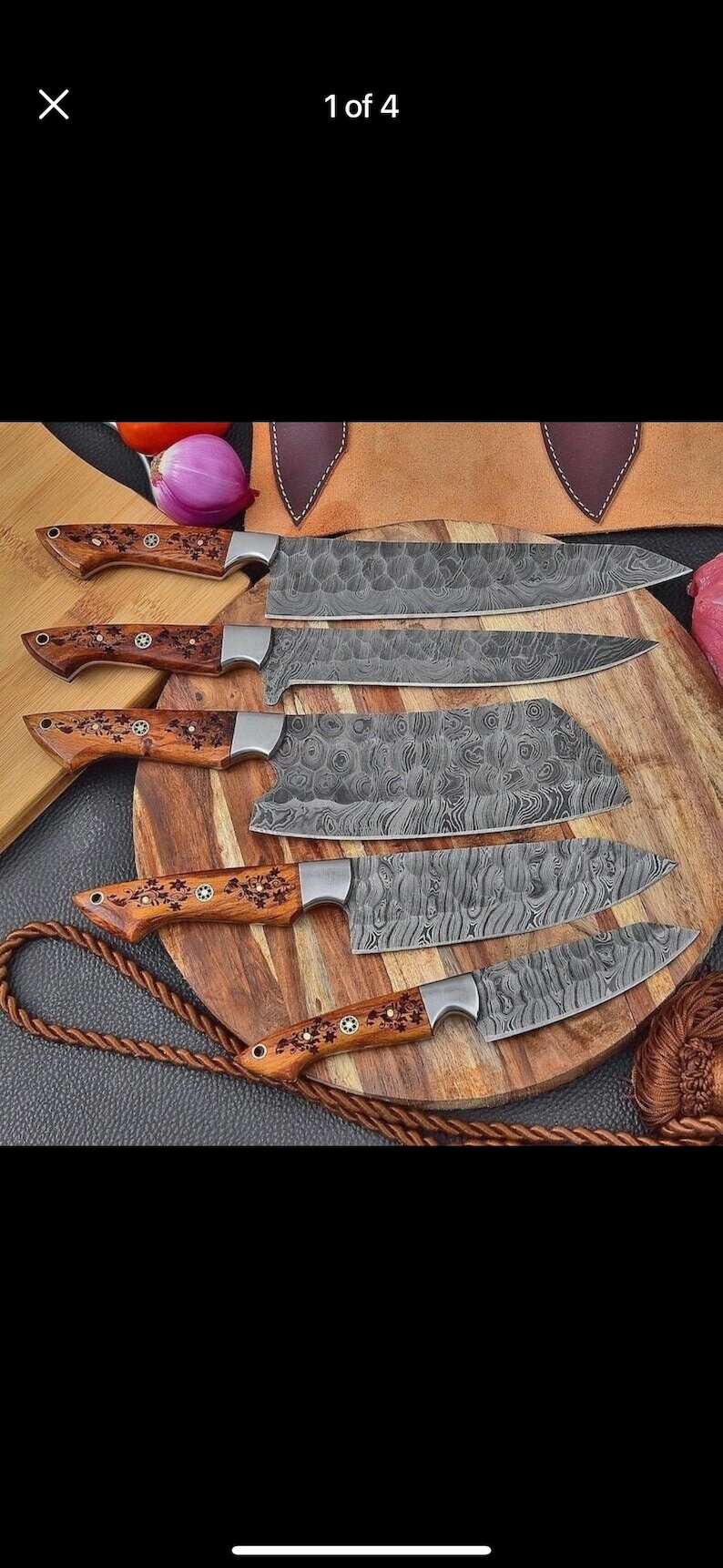 May include: A set of six Damascus steel kitchen knives with wooden handles. The blades have a unique patterned design. The handles are decorated with floral accents. The knives are displayed on a wooden cutting board.