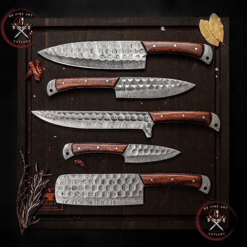 May include: An overhead shot showcases a set of five Damascus steel kitchen knives with wooden handles. The blades have a unique patterned design. The knives are arranged on a dark wooden cutting board, with a logo in the top left and bottom right corners.