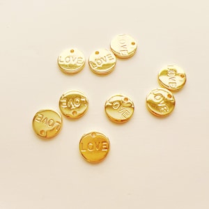 May include: Nine gold-colored metal charms with the word "LOVE" embossed on each charm.