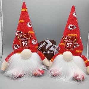 May include: A set of three ceramic mugs with a speckled, cream-colored glaze. Each mug features a different hand-painted floral design in shades of blue, green, and yellow. The mugs have a simple, modern shape.