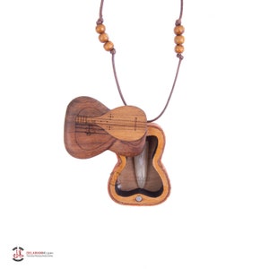 May include: A wooden guitar-shaped pendant necklace with a brown cord. The pendant opens to reveal a small compartment inside.