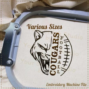 May include: Embroidery machine file design featuring a brown and black cougar head with the text "COUGARS FOOTBALL" in a vertical design. The design is on a white fabric background.