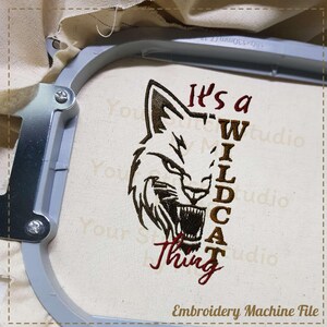 May include: Embroidery design file for a machine embroidery project. The design features a stylized wolf head with the text "It's a Wildcat Thing" in a vertical format.