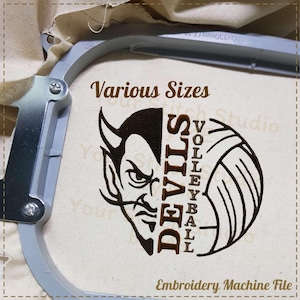 Puede incluir: Un bastidor de bordado sostiene una tela beige con un diseño de diablo y voleibol marrón. El texto dice "Various Sizes" y "Devils Volleyball". Las palabras "Embroidery Machine File" también son visibles.