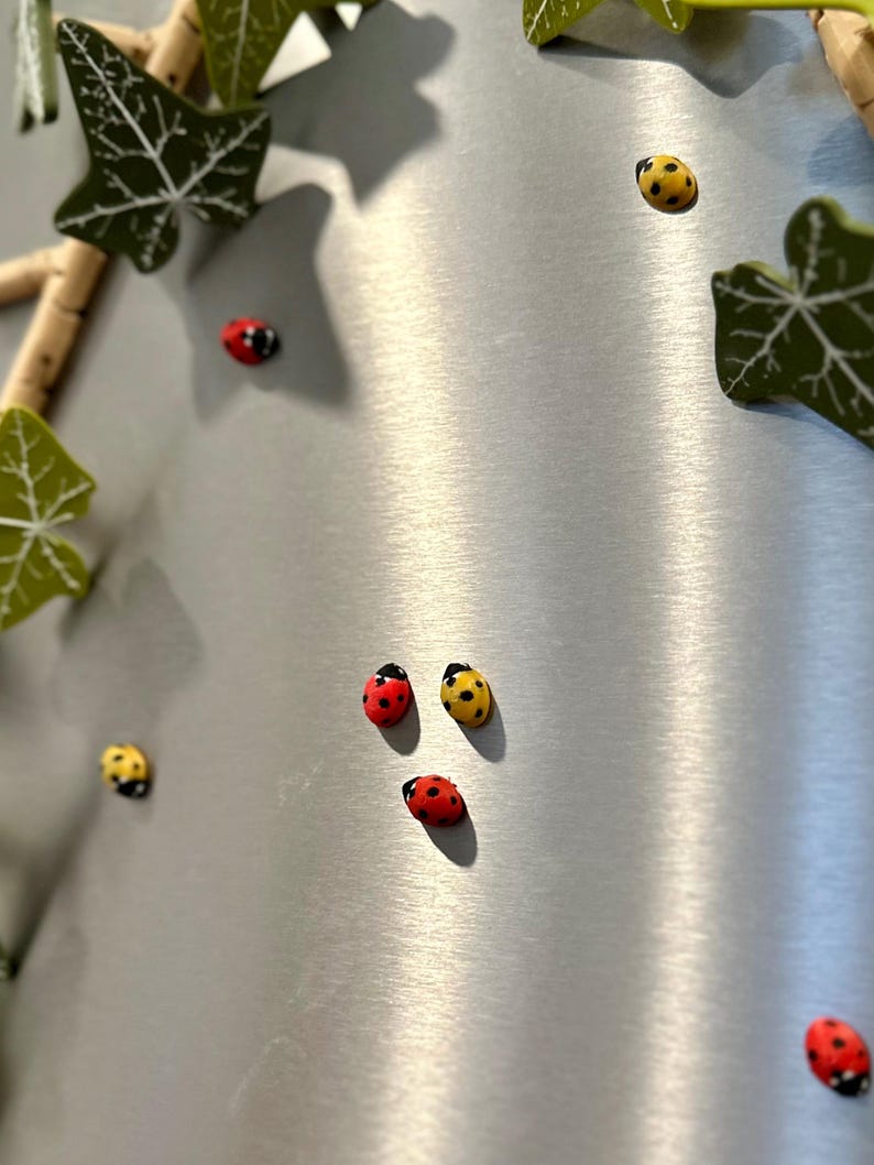 May include: A silver background with a variety of red and yellow ladybugs. The ladybugs are arranged in a random pattern.