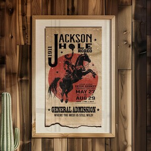 May include: A vintage poster advertising the Jackson Hole Rodeo in Teton County, Wyoming. The poster features a cowboy riding a bucking bronco with a red sun in the background. The dates of the rodeo are May 27th to August 29th. The text on the poster reads "Jackson Hole Rodeo, Teton County, Wyoming, May 27 - Aug 29, General Admission, Where the West is Still Wild!"