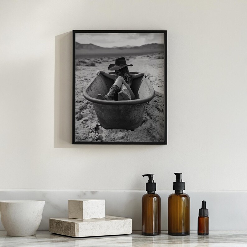 K&ouml;nnte beinhalten: Schwarzwei&szlig;foto einer Frau mit Cowboyhut und Stiefeln, die in einer Badewanne in der W&uuml;ste entspannt.