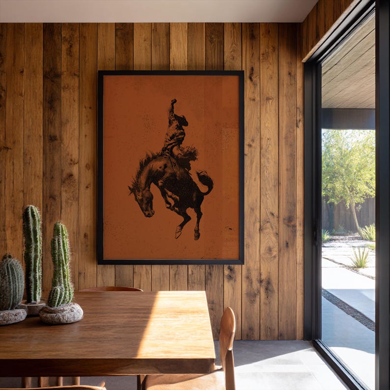 Cowboy bronc rider wall art on rust-orange background, vintage rodeo-inspired Western print.