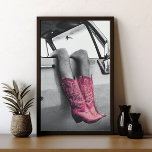 May include: A black and white photograph of a person's legs sticking out of a car window. The person is wearing pink cowboy boots.