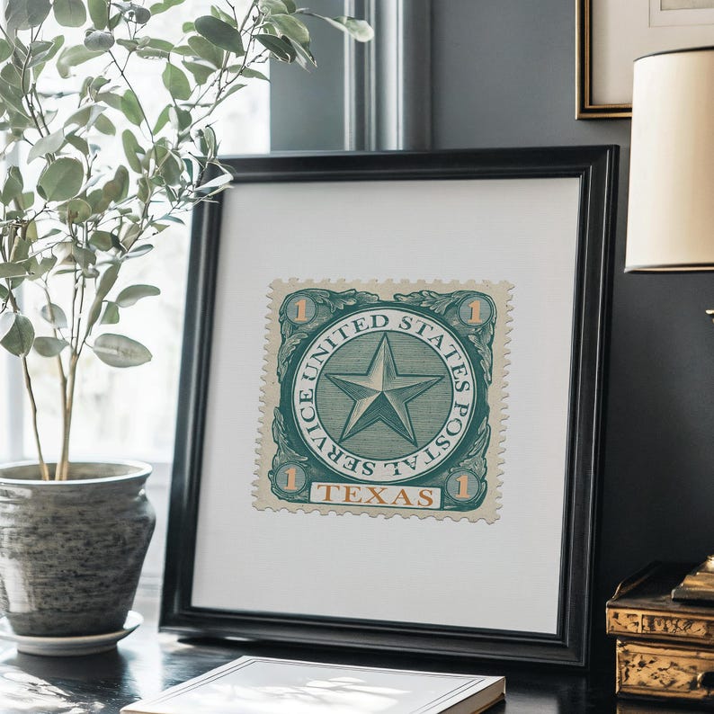 K&ouml;nnte beinhalten: Gerahmte Vintage-Briefmarkenkunst mit einer gr&uuml;n-wei&szlig;en Briefmarke mit Sterndesign. Die Briefmarke tr&auml;gt die Aufschrift "United States Postal Service Texas" und ist in einem schwarzen quadratischen Rahmen gerahmt. Das Kunstwerk wird auf einer schwarzen Oberfl&auml;che ausgestellt.