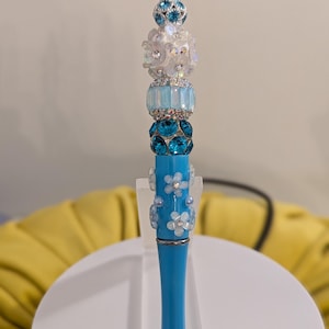 Blue beadable pen with floral accents and fancy sparkly beads