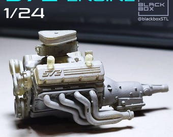 May include: A detailed model of a 572 engine, 1/24 scale, in a light gray color. The engine features intricate components like exhaust headers, a carburetor, and valve covers. The text "572 ENGINE" and "1/24" are visible in the image.
