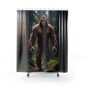 May include: A shower curtain featuring a brown Bigfoot standing in a forest. The Bigfoot is looking directly at the viewer with a serious expression.