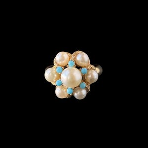 May include: A gold ring featuring a floral design. The ring is adorned with large, creamy white pearls and small, round turquoise stones. The ring's setting is gold, and the design is centered on a black background.
