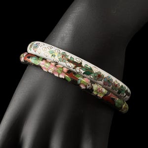 May include: A white ceramic mug with a black handle and the text "But First, Coffee" in a bold, black font. The mug is set against a blurred background, suggesting a cozy setting.